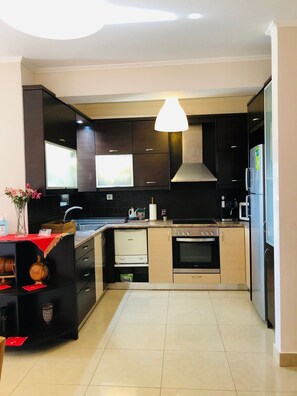A modern kitchen with dark cabinetry, a stainless steel oven, a microwave, and a built-in dishwasher. - Ariadni's apartment 1 in Chania city (Chania)