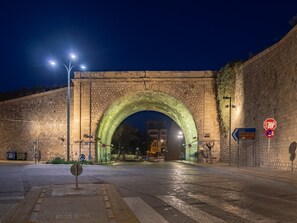 A stone archway at night with street lamps and directional signs. - Cozy Luxury Apartment 2 In The Center Of Heraklion (Iraklio)