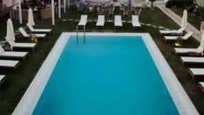 A pool with lounge chairs and umbrellas, a clear view of the ocean, and a structure in the background. - "Havana 5" Studio Sea and Pool (Gazi)