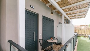 A balcony with a table and chairs, a closed door, and a covered area with a ceiling. - "Havana 5" Studio Sea and Pool (Gazi)