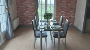 A dining area with a brick wall, a table set for four, and a view of the outdoors.