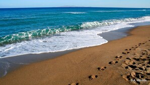 Une plage où l’on voit des empreintes de pas dans le sable et les vagues qui se rapprochent du rivage.