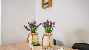 Two glass vases with plants on a wooden table, a small square planter, and two spherical candles. - "Malena" Nature and Sea View House (Sidonia)