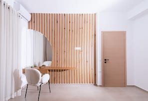 Ein Zimmer mit einer Holzwand, einer Holztür, einem weißen Stuhl, einem Tisch und einer weißen Klimaanlage.