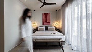 Ein modernes Schlafzimmer mit einem Bett, einem Deckenventilator und zwei Nachttischlampen.