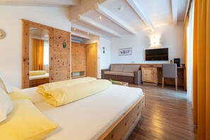 Un dormitorio con cama, armario de madera, sofá, escritorio y televisor.