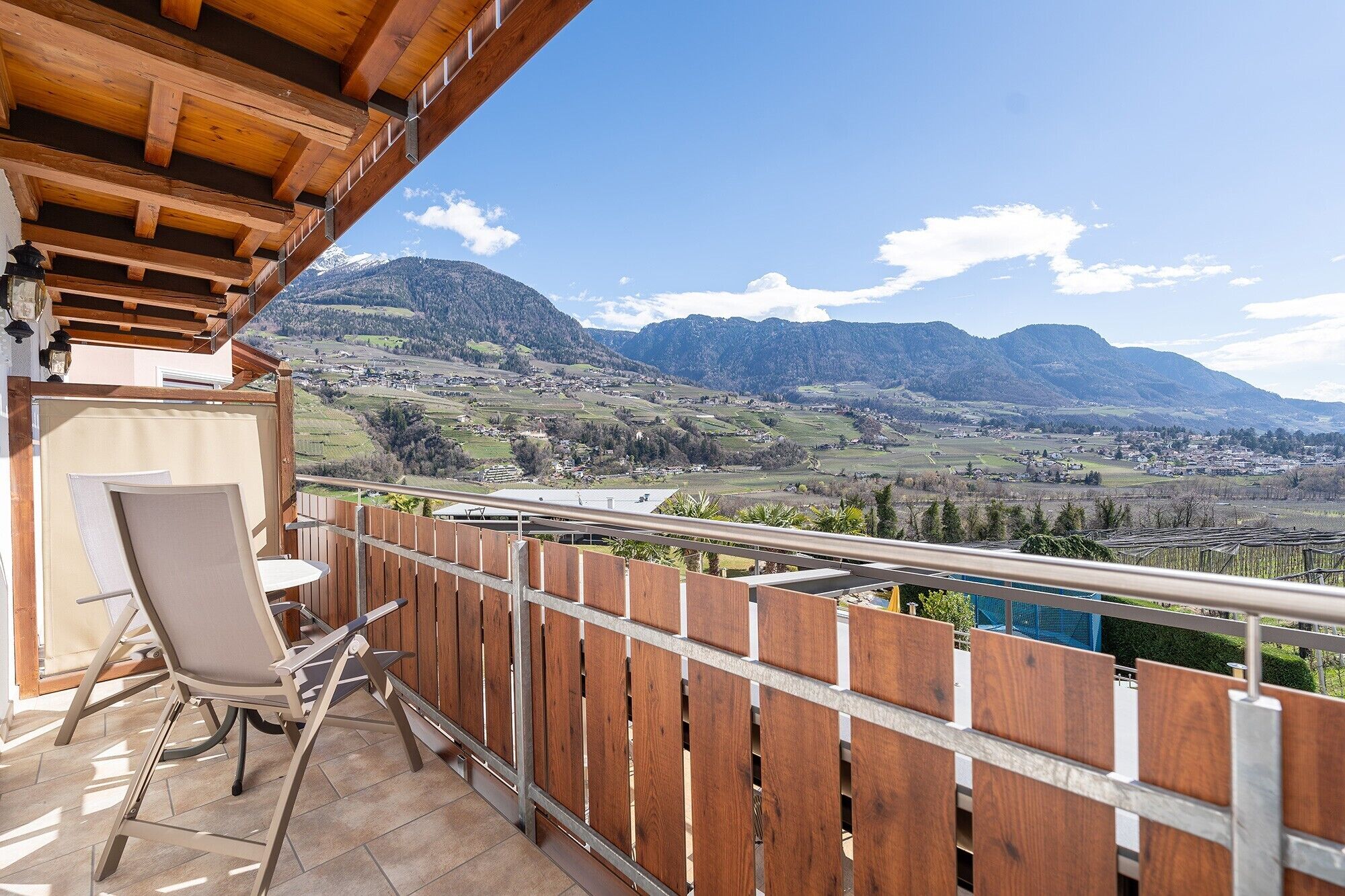 Un balcón con vistas a un valle y montañas.