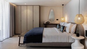 Ein modernes Schlafzimmer mit Bett, Nachttisch, Lampe und einem großen Spiegel.