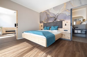 Ein modernes Schlafzimmer mit einem Holzbett, einer Marmor-Wandmalerei und einem integrierten Schminktisch mit Spiegel.