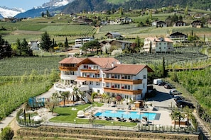 A multi-story hotel with a pool area, surrounded by vineyards and mountains. - Room 'Passerblick Suite 5' with Mountain View, Wi-Fi and Air Conditioning (Tirolo)