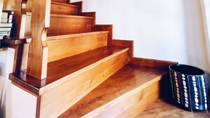 A wooden staircase with a handrail, a black bag on the landing, and a painting on the wall. - Hidden Tuscan Gem- surrounded by rolling hills. Charming villa, sleeps up to 6. (Caprese Michelangelo)