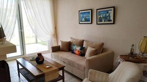 Ein Wohnzimmer mit einer Couch, einem Couchtisch und zwei gerahmten Bildern an der Wand.