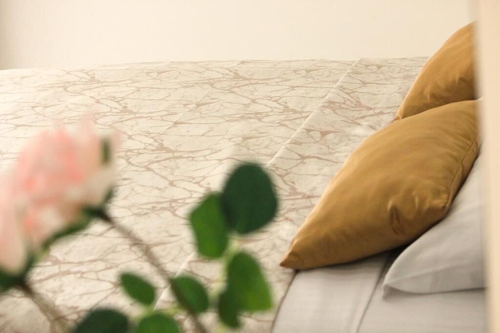 A bed with patterned bedding and two pillows.