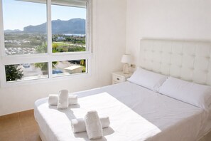 A hotel room with a bed, a nightstand, a lamp, and a window with a view of a landscape. - Anacasa Albatros MET Oliva Nova Golf AT469 (Oliva)