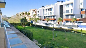 A residential area with modern apartment buildings, a well-maintained lawn, and a clear sky. - Anacasa Albatros MET Oliva Nova Golf AP465 (Oliva)