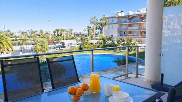 A balcony with a table, a glass bowl of oranges, a glass of orange juice, and a white mug. - Anacasa Albatros MET Oliva Nova Golf AP465 (Oliva)