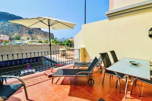 A terrace with a pool, lounge chairs, a table, and an umbrella. - Casa Melinda  - Playa de Mogan (Lomo Quiebre)