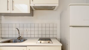 Una cocina con un lavamanos, estufa y refrigerador.