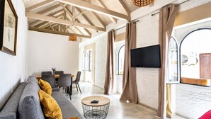 A modern living room with a sofa, coffee table, and dining area. - Casa San Vicente Olehousing 3 (Sevilla)