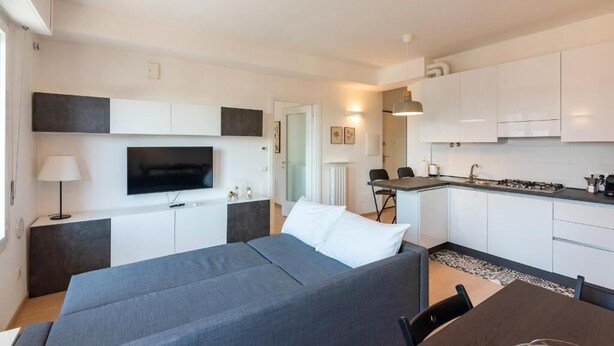 Une chambre moderne équipée d’un lit, d’une télévision, d’une kitchenette et d’un coin repas.