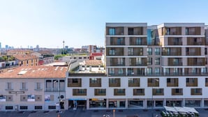 Un immeuble à plusieurs étages doté d’une architecture moderne, avec des balcons et de grandes fenêtres.