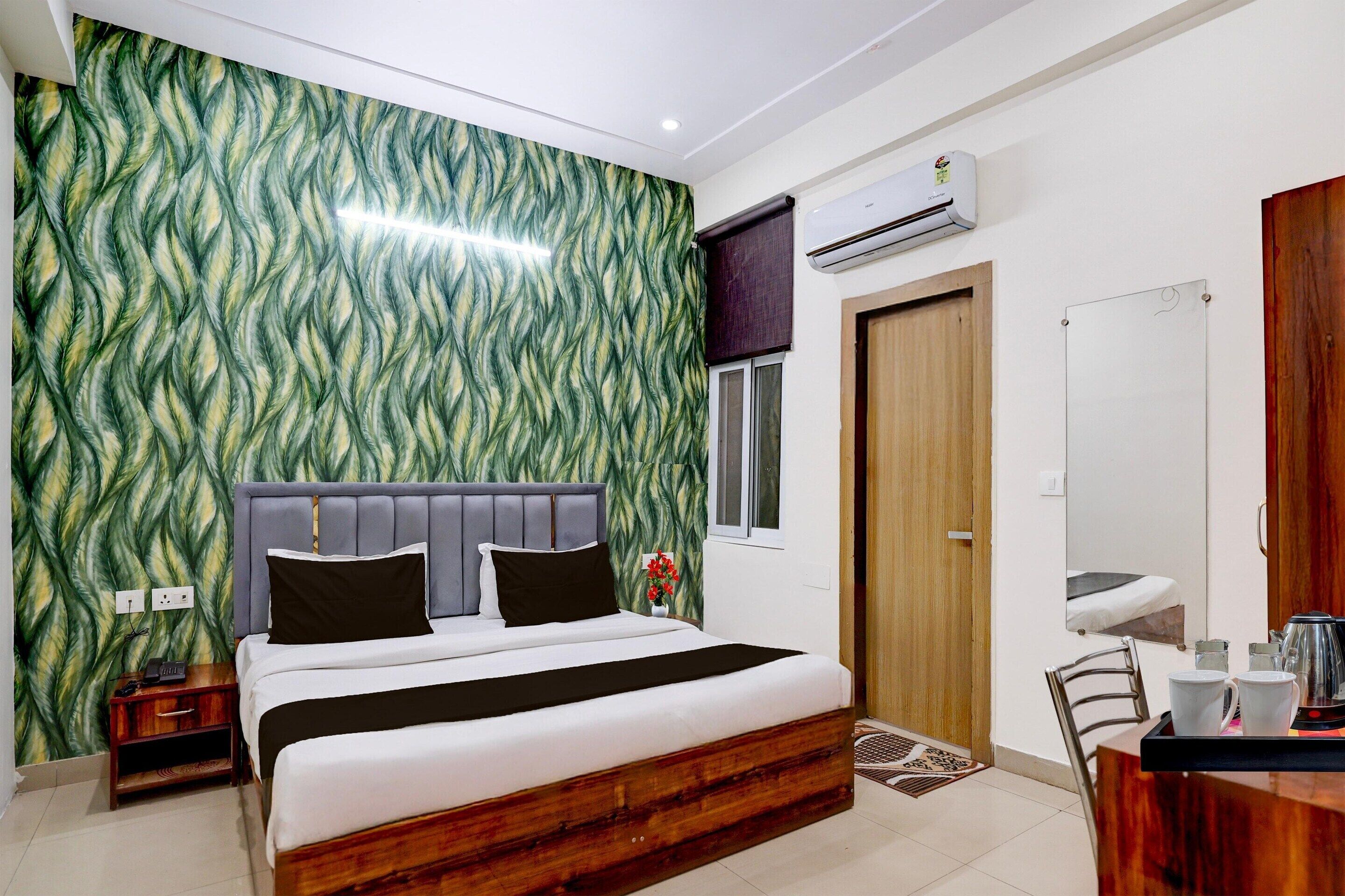 Un dormitorio con cama, mesita de noche, cómoda y espejo.
