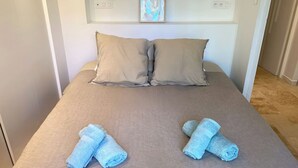 A bed with two pillows, a framed picture on the wall, and two rolled towels on the bed. - Villa sleeps 10 with heated pool & jacuzzi and breathtaking views (Coux and Bigaroque-Mouzens)