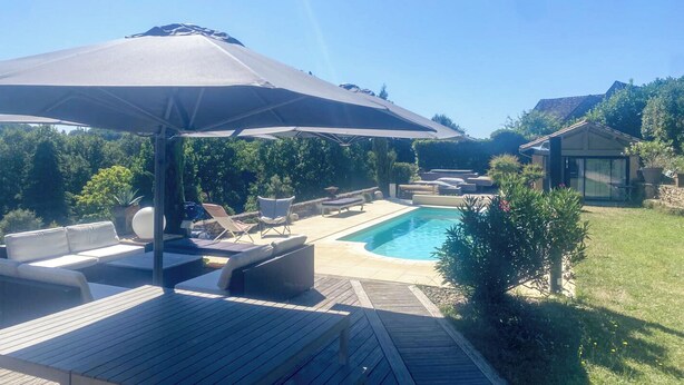 A backyard with a pool, lounge chairs, and a covered patio area. - Villa sleeps 10 with heated pool & jacuzzi and breathtaking views (Coux and Bigaroque-Mouzens)