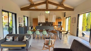 Un intérieur moderne comprenant un coin repas, des canapés et une cuisine.