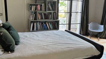 Une chambre à coucher avec un lit, une bibliothèque, une fenêtre et une chaise.