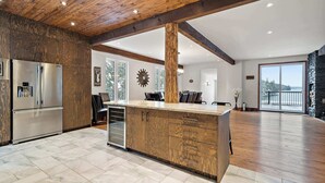 Una cocina moderna con una isla de madera, electrodomésticos de acero inoxidable y un amplio ventanal con vistas al exterior.