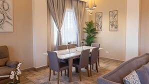 A dining area with a table, chairs, and a plant. - BELLEVIEW APARTMENTS (Kampala)