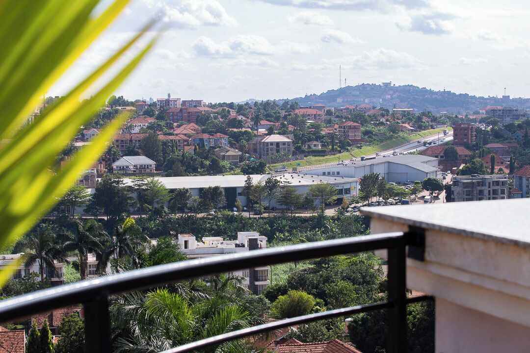 A cityscape with buildings, a river, and greenery.