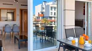 Eine moderne Küche mit Essbereich, ein Balkon mit Tisch und Stühlen und Blick auf die Stadt.
