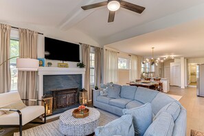 A living room with a fireplace, sofa, TV, and a ceiling fan. - 4-bedroom house 5 min from Masters - back apartment - two kitchens - BBQ - games (Augusta)