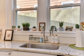 A kitchen with a sink, countertop, and potted plants. - 4-bedroom house 5 min from Masters - back apartment - two kitchens - BBQ - games (Augusta)
