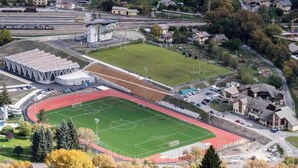 En stadion med en löparbana, en fotbollsplan och en liten byggnad med en klocka.