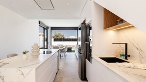Une cuisine moderne dotée d’un plan de travail en marbre, d’appareils électroménagers en acier inoxydable et d’un coin repas offrant une vue agréable.