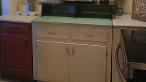 A kitchen with white cabinets, a microwave, a coffee maker, and a toaster. - Tranquil 1-bedroom cottage with AC in charming Augusta near the Masters! (Augusta)