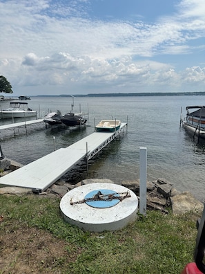 A lakeside dock with boats, a concrete platform, and a grassy area. - 2-bedroom mobile home in Henderson (Henderson)