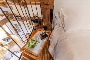 A bedroom with a wooden bed frame, a bedside table with a book and a cup, and a view of the room's interior. - ROMANTIC ATTIC WITH A VIEW OF THE GRAND CANAL (VENEZIA)