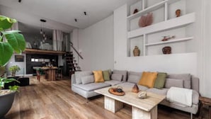 Un salon moderne avec un canapé d’angle, une table basse et une bibliothèque.