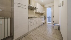 Una cocina moderna con armarios blancos, una estufa a gas y un horno empotrado.