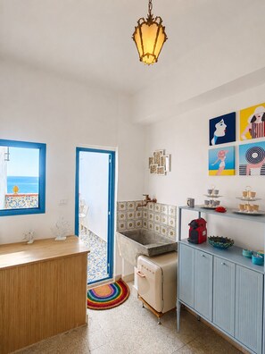 A kitchen with a countertop, a refrigerator, a sink, and a hanging light fixture. - Belvedere & Blu - Panorama 180° - Breathtaking Ocean View (Sciacca)