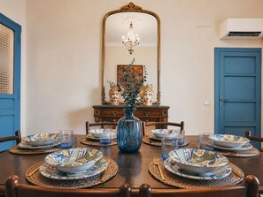 A dining table set for six with blue and white patterned plates, a blue vase with greenery, and a mirror above. - Belvedere & Blu - Panorama 180° - Breathtaking Ocean View (Sciacca)