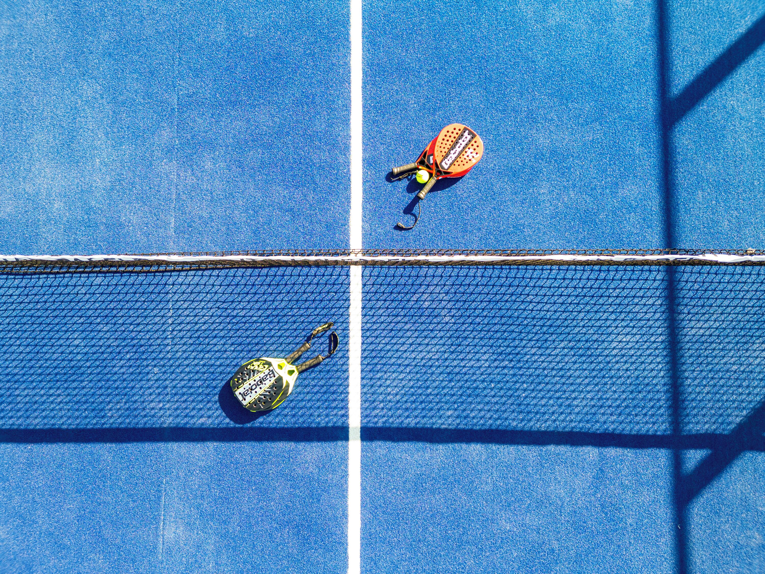 Un campo da tennis con una rete e due racchette.