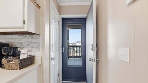 A narrow hallway with a dark door, a white door, and a basket on a counter. - Sea Cabin Shores w Pool View and Ocean Peek (North Myrtle Beach)