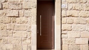 A brown door with a handle, a window above it, and a sign with the number '21A' on the wall. - Apartment 'Lu Marchese' with Private Terrace, Wi-Fi and Air Conditioning (Minervino di Lecce)