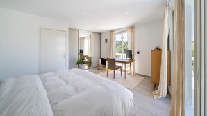 Ein Schlafzimmer mit einem großen Bett, einem Schreibtisch, einem Stuhl und einem Kleiderschrank.