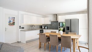 Eine moderne Küche mit weißen Schränken, einem Holztisch und einem eingebauten Backofen.